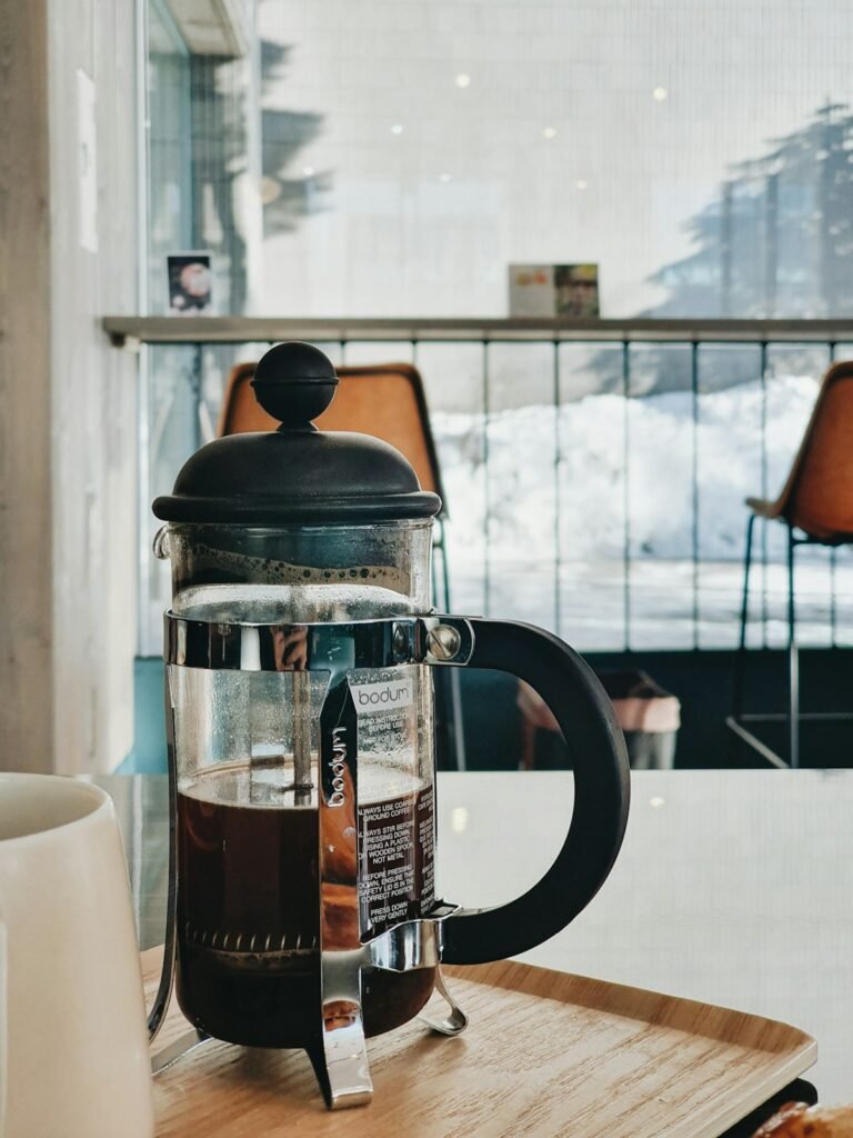 Cafetière à piston posée sur une table près d'une fenêtre