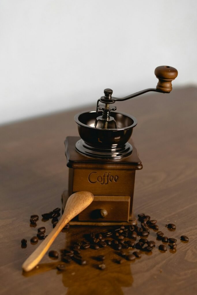 Moulin à café manuel en bois avec une cuillère et des grains de café